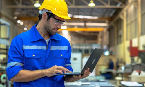 man with laptop in warehouse